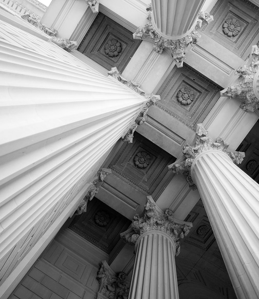 Architecture Classique en Noir et Blanc : Colonnes Sculptées Vue en contre-plongée de colonnes corinthiennes majestueuses et d'un plafond à caissons sculpté en noir et blanc.