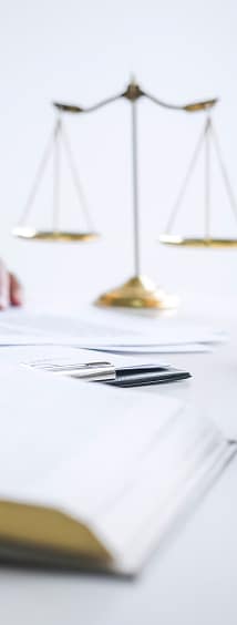 Balance de justice et documents sur un bureau d'avocat Balance de justice dorée en arrière-plan flou avec des documents juridiques et un livre de loi sur un bureau d'avocat.