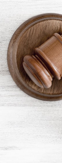 Justice et Droit : Maillet de Juge en Bois sur son Bloc Maillet de juge en bois sur un bloc sonore, posé sur une surface blanche, évoquant la justice et la loi.